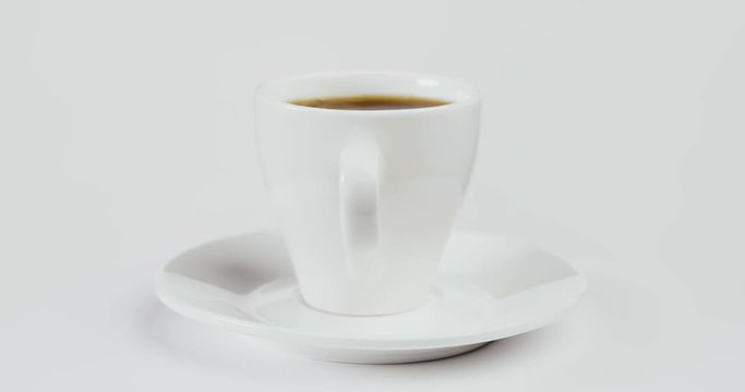 White ceramic cup with coffee and saucer isolated