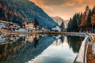 A small town in the Dolomites Italian Alps, a lake, a beautiful urban natural autumn landscape,...