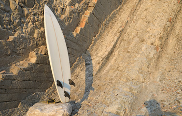 tabla de surf apoyada en la roca 4M0A1338-f18