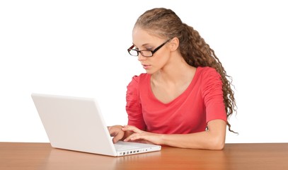 Girl Sitting Behind Desk and Using Laptop - Isolated
