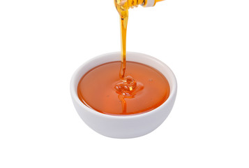 bowl of pouring honey isolated on white background