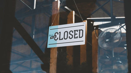 CU closed sign hanging on the entrance door of a small cafe. Out of business