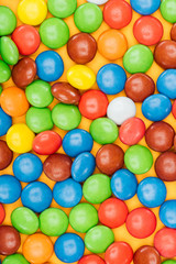 top view of tasty bright dragee candies on yellow surface