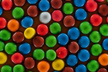 top view of yummy bright dragee candies on brown surface