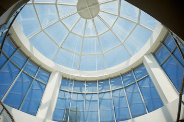 The glazed dome of the modern building. The blue sky is illuminated
