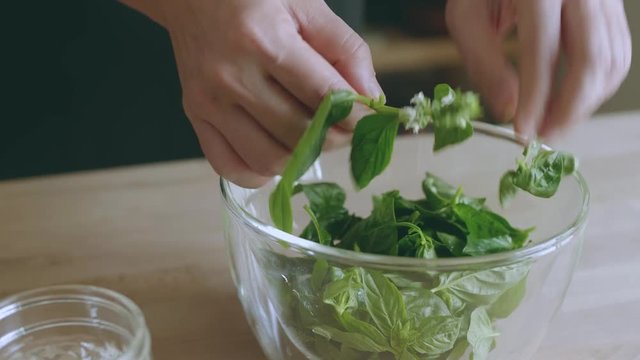 Pull basil leaves from stems and put in a bowl
