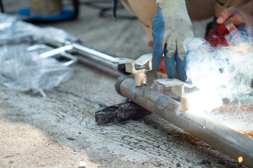 close up technician welding metal pole, dangerous worker.