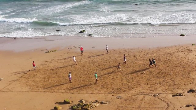 Friends Playing Footabll on the Beach in Morocco