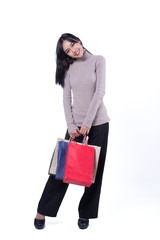 Shopping woman holding shopping bags on white background . Beautiful young  asian shopper smiling happy.