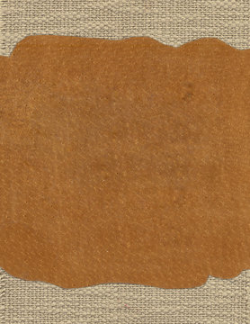Piece of leather on the fabric textile texture background