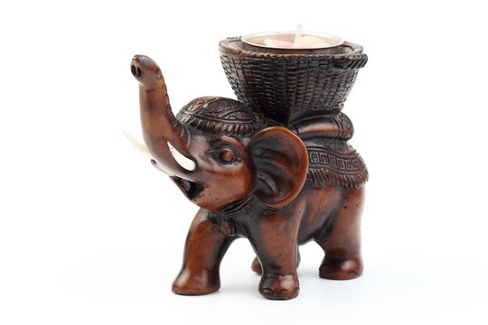 Brown elephant made of resin like wood carving with candle holder with white ivory. Stand on white background, Isolated, Art Model Thai Crafts, For decoration Like in the spa.