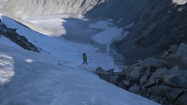 Mountaineer Man in Crampons is Using Ascender on Fixed Rope on Steep Mountain Pass. Slow Motion