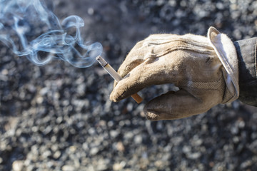 Dirty white glove and fuming tobacco in Finland. The sun is shining strongly on the side.