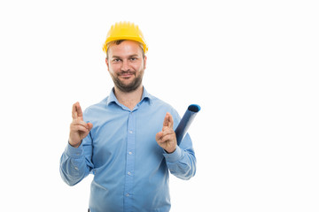 Young architect holding blueprints and showing double cross fingers gesture