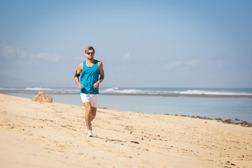 Fototapeta na wymiar handsome sportsman running on sea shore