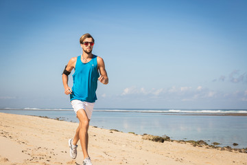 Fototapeta na wymiar jogger training on sand beach near sea, Bali, Indonesia