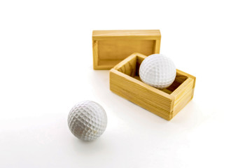 Golf balls in wooden boxes on a white background.
