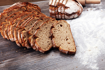 freshly baked bread on wooden board. cutted bread