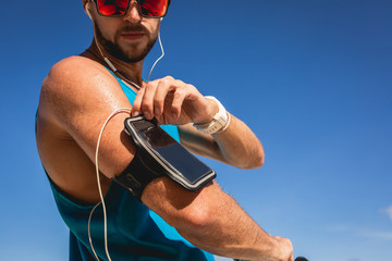 sportsman listening music with earphones and smartphone in armband