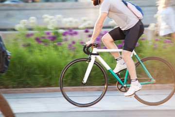 sports guy rushes on the bicycle through the summer city park