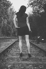 Woman standing on railroad tracks in forest