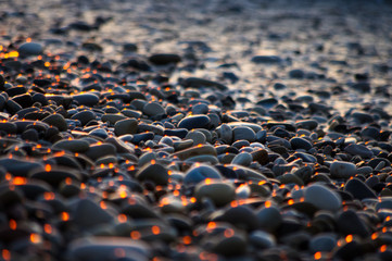 Fototapeta premium pebble stones on the sea beach, the rolling waves of the sea with foam