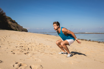 Fototapeta na wymiar young sportsman jumping on sandy beach