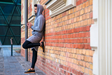 Fototapeta na wymiar Young man next to a brick wall 