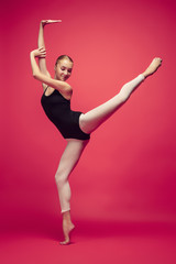 Young teen dancer on red studio background.