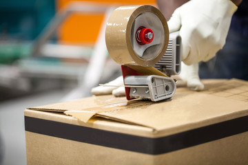 Box being taped shut in packaging plant.