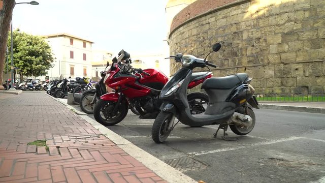 Piombino, Tuscany, Italy. The girl park her motorcycle in the parking lot