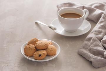 White cup of creamy coffee with butter cookies and stainless teaspoon isolated on white background, clipping path