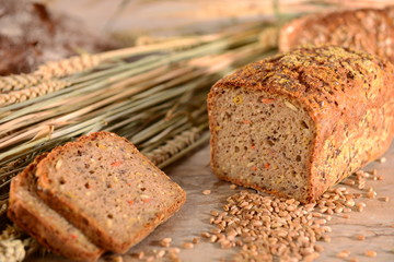 Vollkornbrot mit Getreide, angeschnitten, Brotscheiben, mit Brotlaib im Hintergrund, auf...