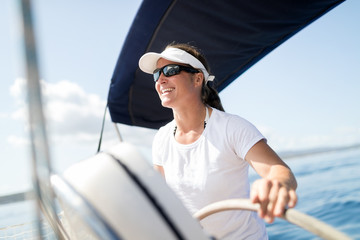 Attractive strong woman sailing with her boat
