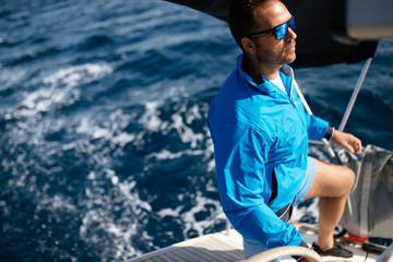 Handsome strong man sailing with his boat