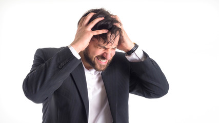 the businessman has a strong headache. He holds his hands on his head and closed his eyes in pain. Close-up portrait. Isolated on white.