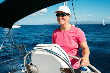 Happy strong woman sailing with her boat