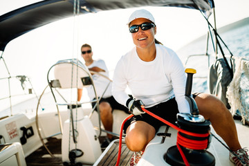 Attractive strong woman sailing with her boat