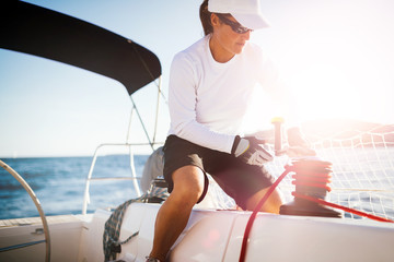 Attractive strong woman sailing with her boat