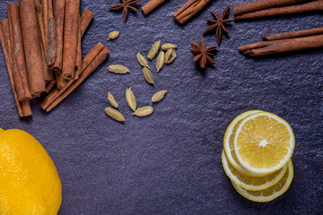lemon, cinnamon, mint and spices on a background of black stone