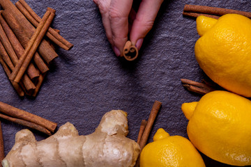 lemon, ginger, cinnamon on a black stone background