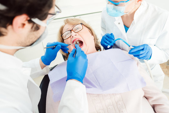 Dentist during treatment of a senior patient seen from above 