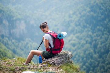 Female hiker sitting and enjoying in breathtaking view