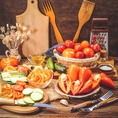 different tomatoes and sweet pepper on a wooden background. rustic food.