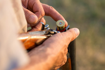Charges a hunting smooth-bore rifle, hunting a pheasant with dogs