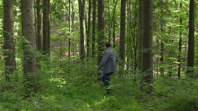 Business man lost in the forest outdoors looking for phone signal. Concept for business challenge and searching for an idea or vision