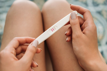 cropped shot of young woman holding pregnancy test
