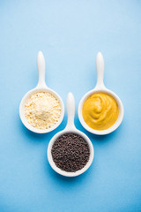 Rai or raw Mustard with sauce, powder and oil, over moody background. Selective focus
