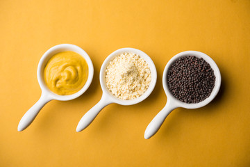 Rai or raw Mustard with sauce, powder and oil, over moody background. Selective focus
