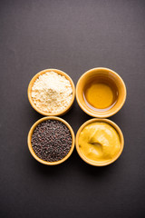 Rai or raw Mustard with sauce, powder and oil, over moody background. Selective focus
